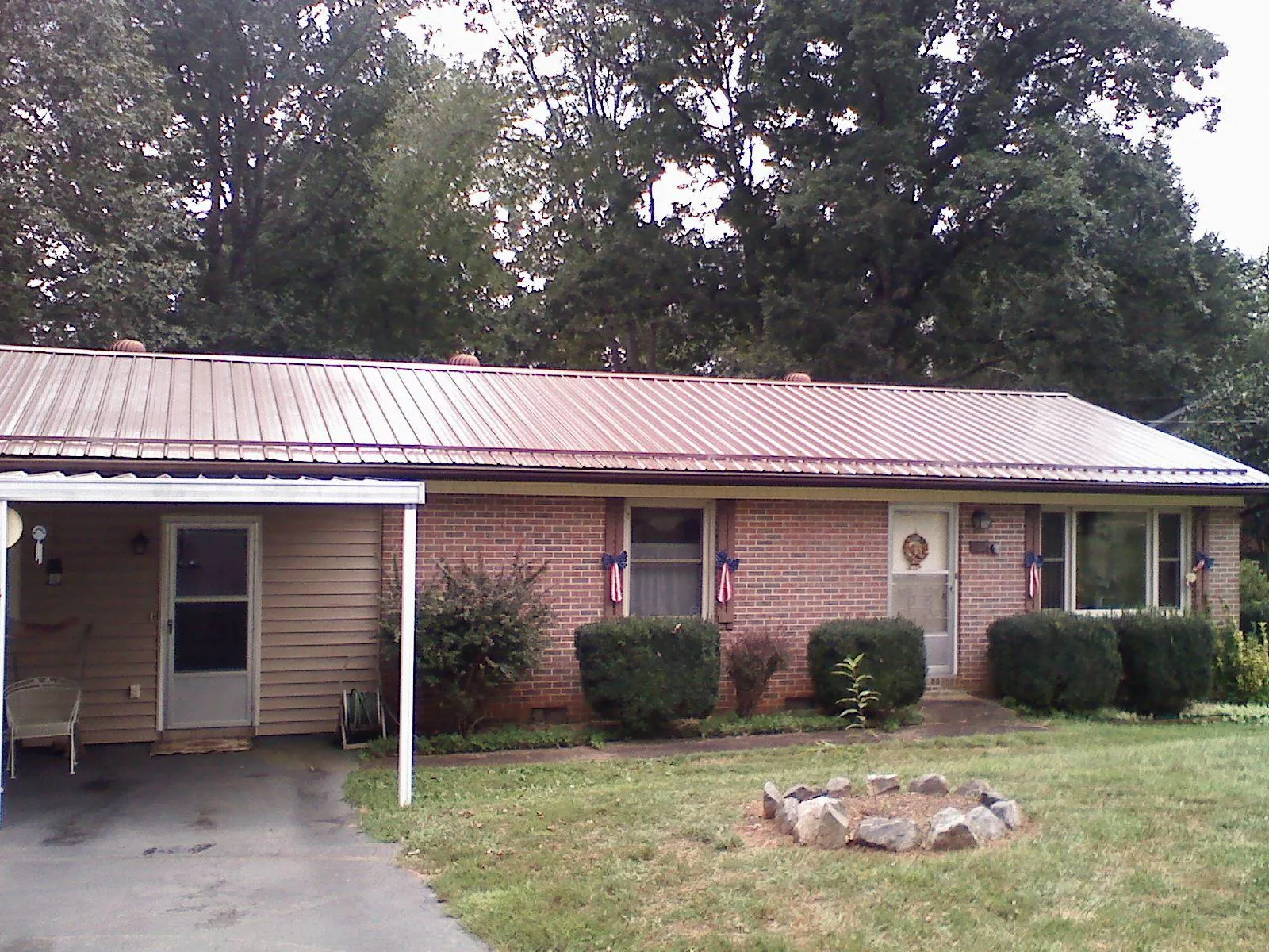 Bronze metal roof and carport on a brick ranch home — Roof Repair work by our crew in Fort Branch